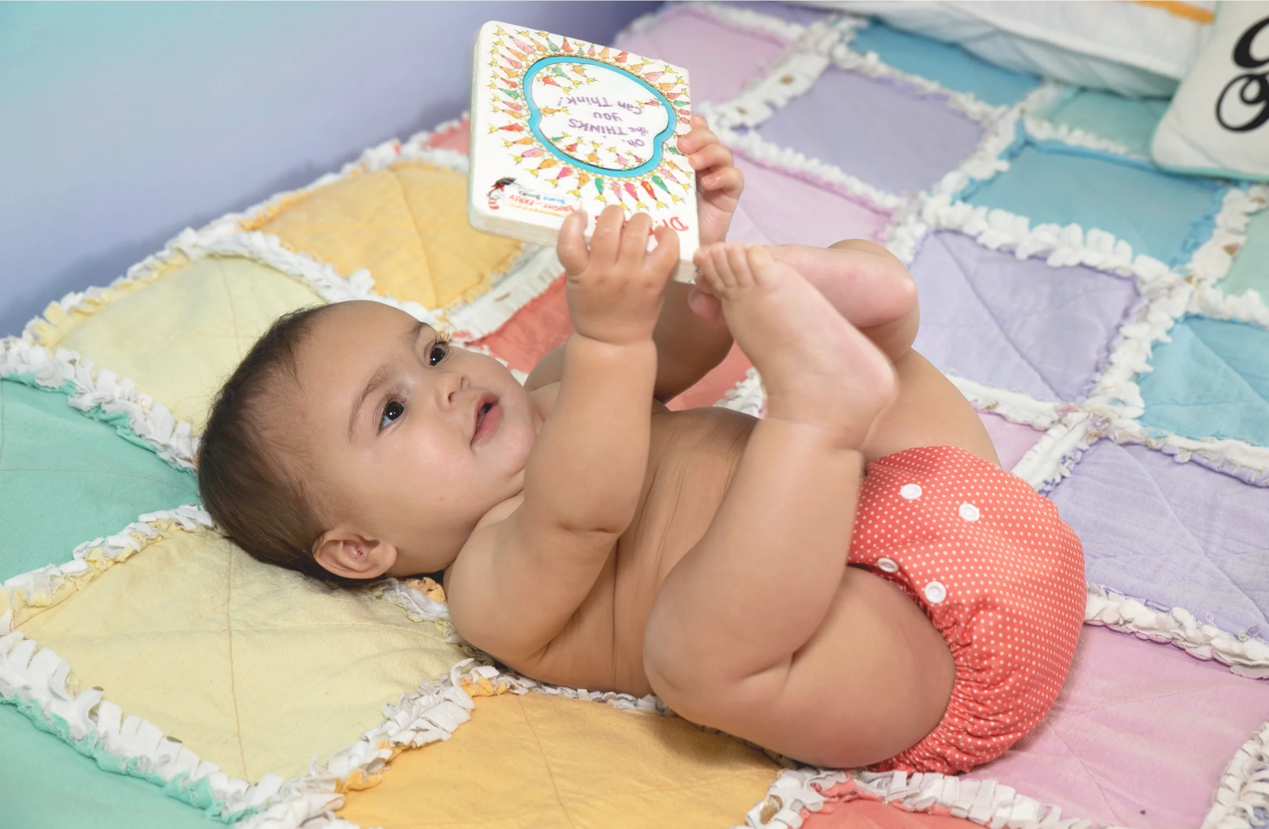 Baby on bed with a book